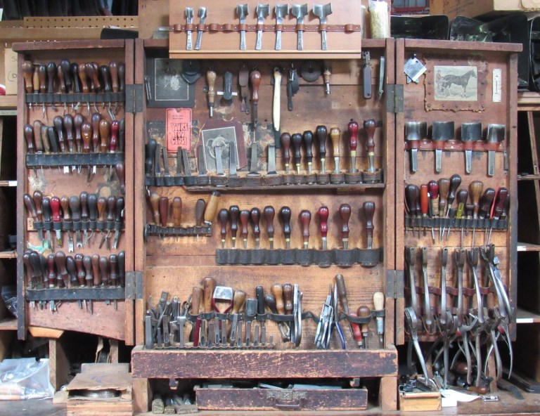 Standing in the Bowman Harness workshop is an intriguing antique cabinet whose open doors reveal rows of vintage hand punches, most of which belonged to Joe Bowman Jr.’s grandfather. Standing in the Bowman Harness workshop is an intriguing antique cabinet whose open doors reveal rows of vintage hand punches, most of which belonged to Joe Bowman Jr.’s grandfather.