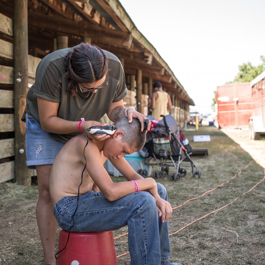 Ella Brewer giving Kayden Brings Plenty a trim (Nate Bressler) Ella Brewer giving Kayden Brings Plenty a trim (Nate Bressler)
