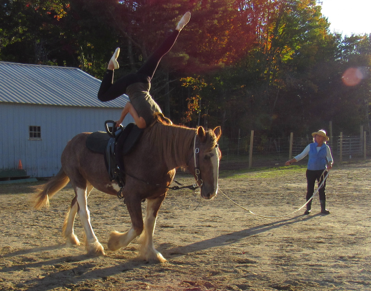 Cynthia Andrews performs the two-part “scissors” on Rosie as her mother guides the trotting draft horse. The rider’s legs are first thrust back propelling the vaulter. Ellsworth American Photo by Maxwell Hauptman Cynthia Andrews performs the two-part “scissors” on Rosie as her mother guides the trotting draft horse. The rider’s legs are first thrust back propelling the vaulter. Ellsworth American Photo by Maxwell Hauptman